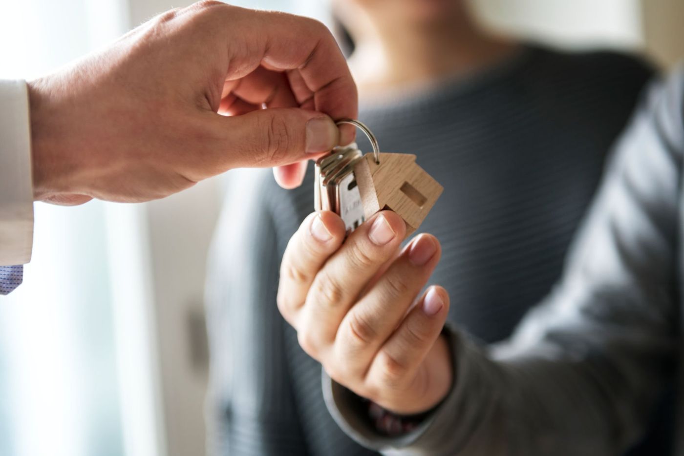 Man holding keys with wooden house charm attachment